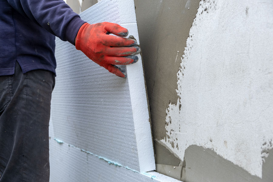 Worker places installation on prepped wall.