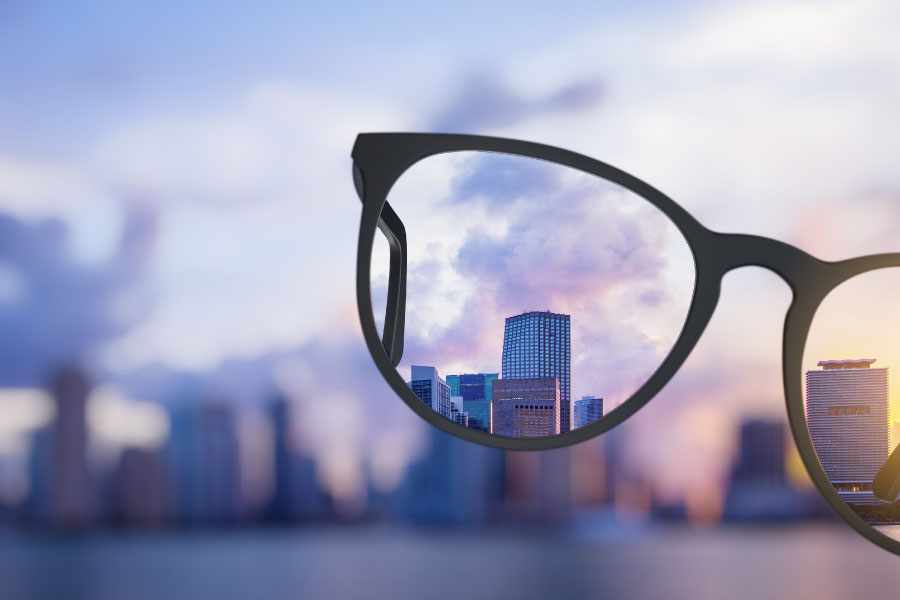 A pair of glasses clear the view of the city skyline in the distance.