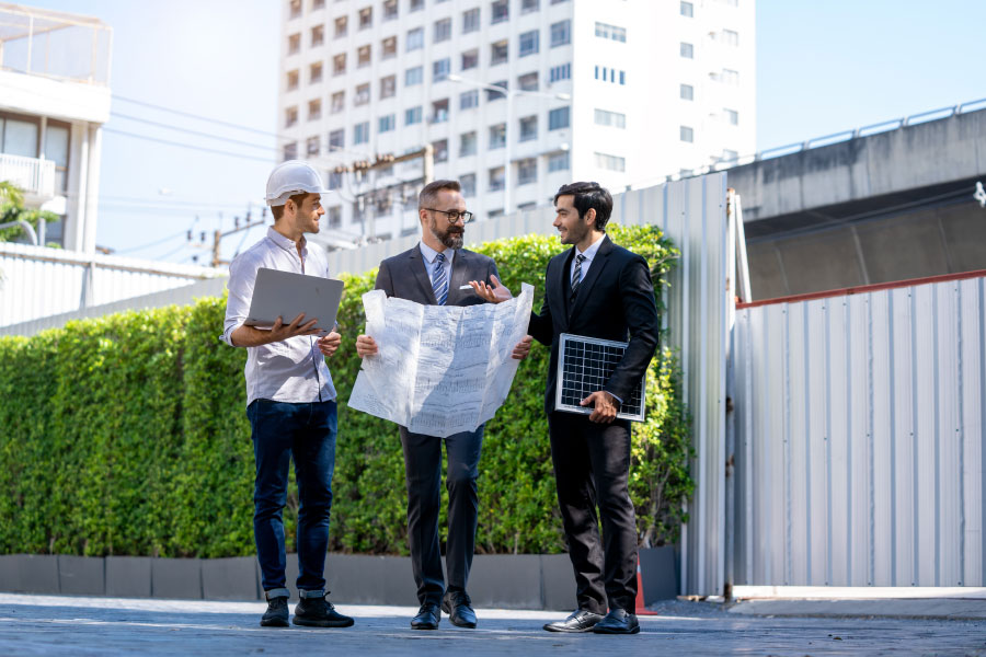 Three men gather to discuss development plans.