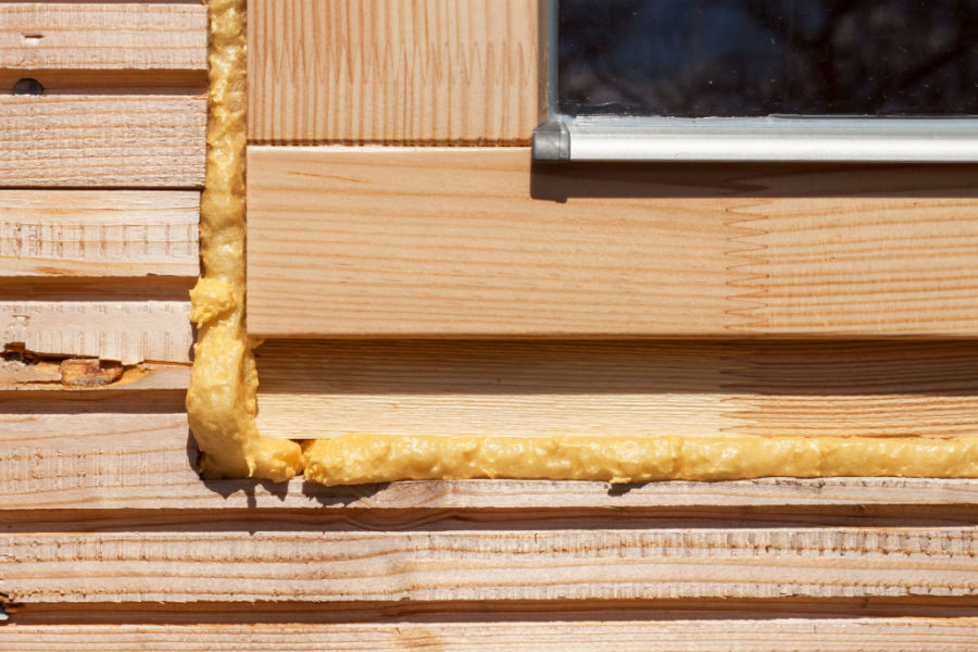 Close up of foam insulation on rim of window edge to prevent air leak.