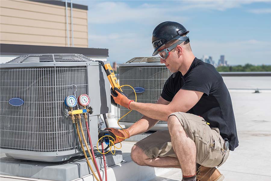 A man is working on an air conditioning unit.