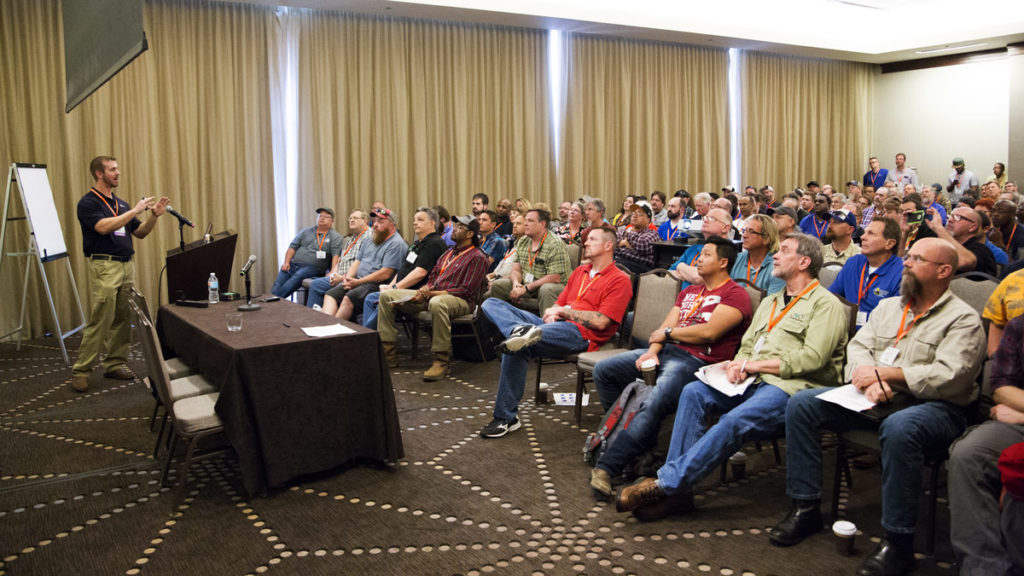 A photo of a group of people in a classroom with a presenter.