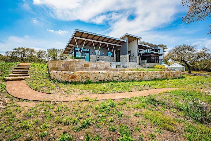 A beautiful home with stone siding, large windows and modern accents.