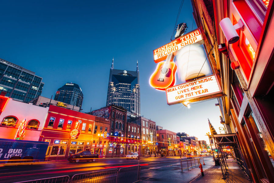 Photo of a busy street in Nashville at night. A sign reads, "Ernest Tubb Record Shop, Real Country Music Lives Here, Our 71st Year"