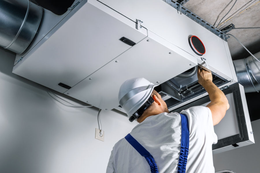 Man works on an HVAC unit.