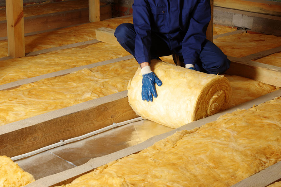 Photo of a worker laying insulation into the floors.