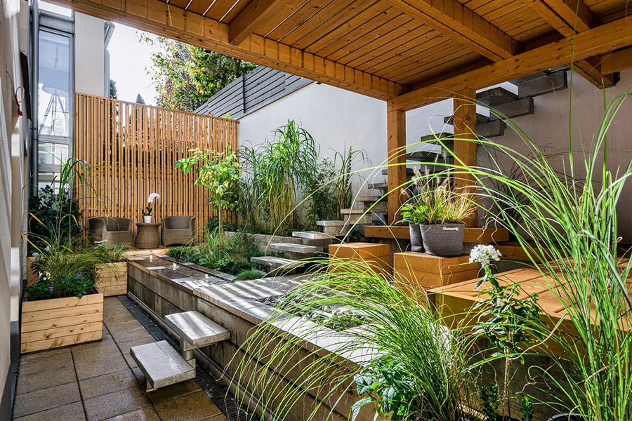 Photo of a spacious porch filled with greenery and wood work.