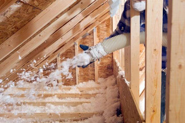 Photo of someone using a machine to fill a roof with insulation