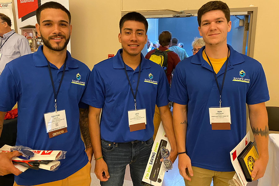 Three men pose and smile for a picture at a BPA event.