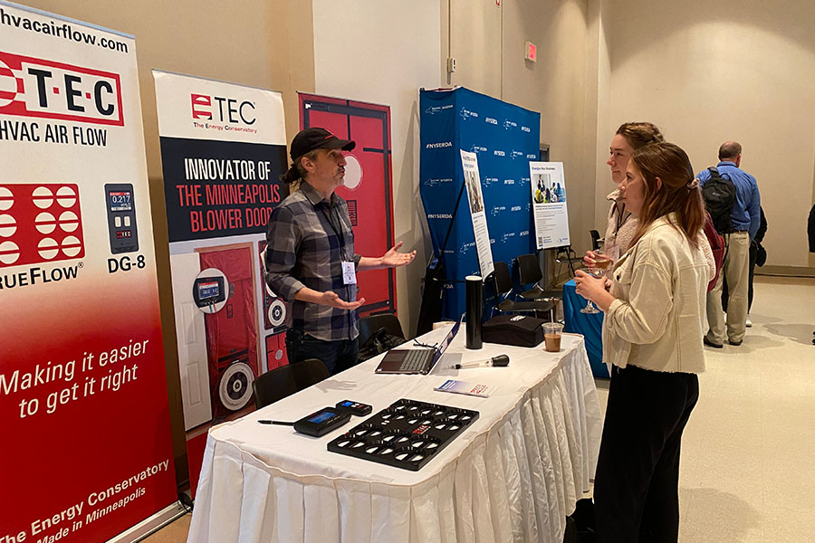 Two women explore the BPA trade show and the TEC booth.