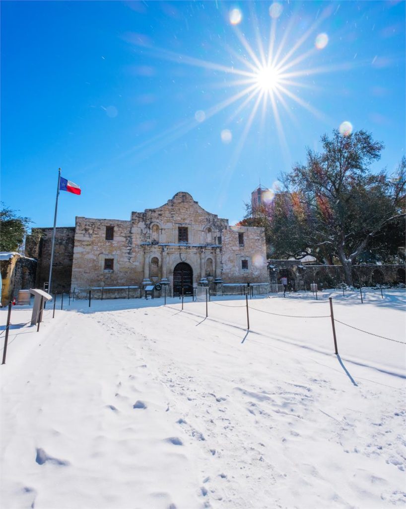 Snow covers the ground in Texas as the sun shines brightly.