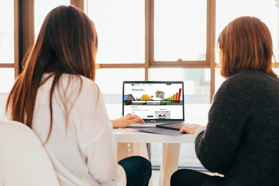 Two women exploring job opportunities on a laptop of the BPA Job Board.
