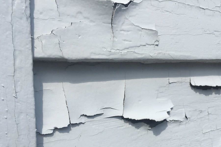 A photo of a building exterior with paint peeling.