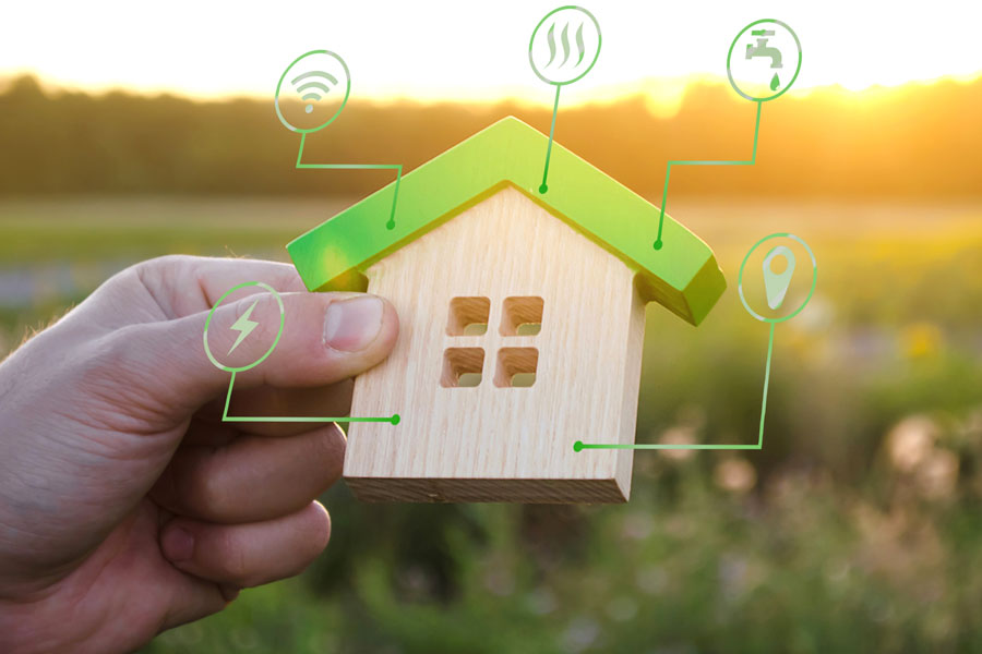 Image of person holding a block house with a lightning bolt, wifi, heat, water faucet, and location pin icon.