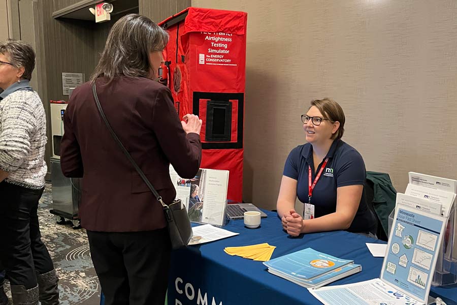 two women talking at commerce department booth at building performance association nationals 2022