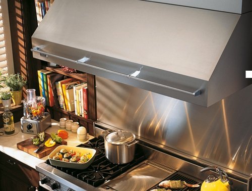 Top view of a range hood with food cooking on the stove.