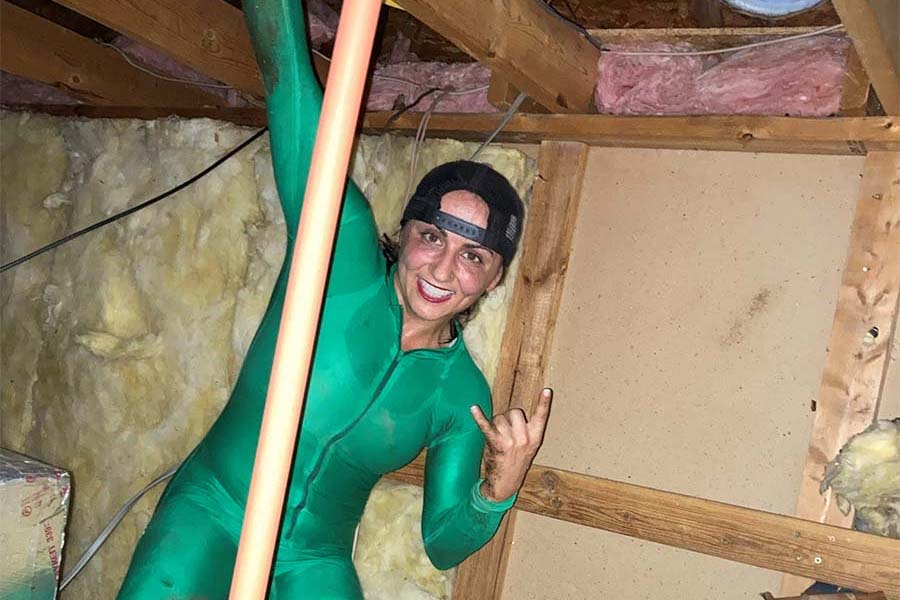 Jessica Azarelo in a body suit inside of the attic of a home.