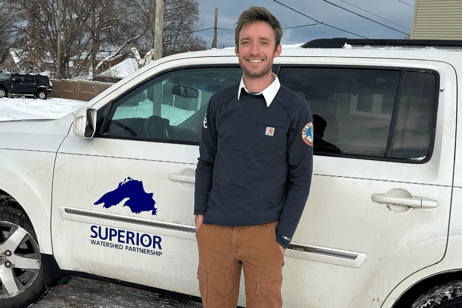 man standing in front of truck smiling