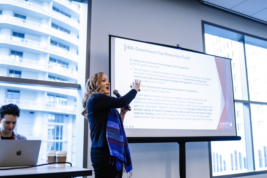 A presenter in the front of a conference room pointing to a slide on a screen. Photo from BPA's 2023 National Home Performance Conference and Trade Show