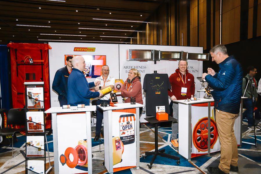 five attendees talking at a booth at NHPC'23