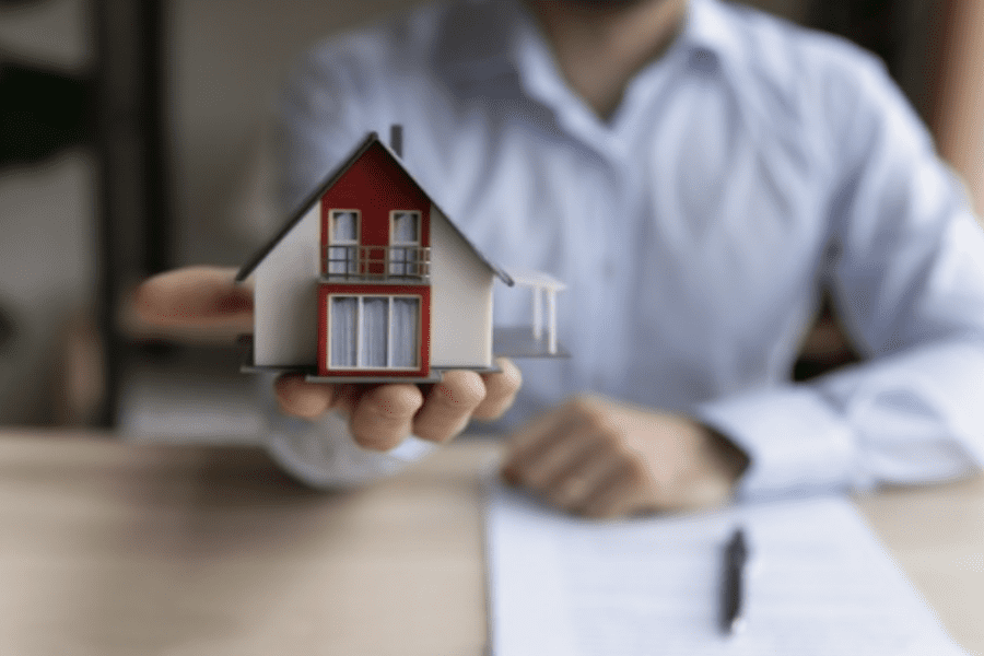 Contractor holding a house to illustrate explaining building science to homeowners.