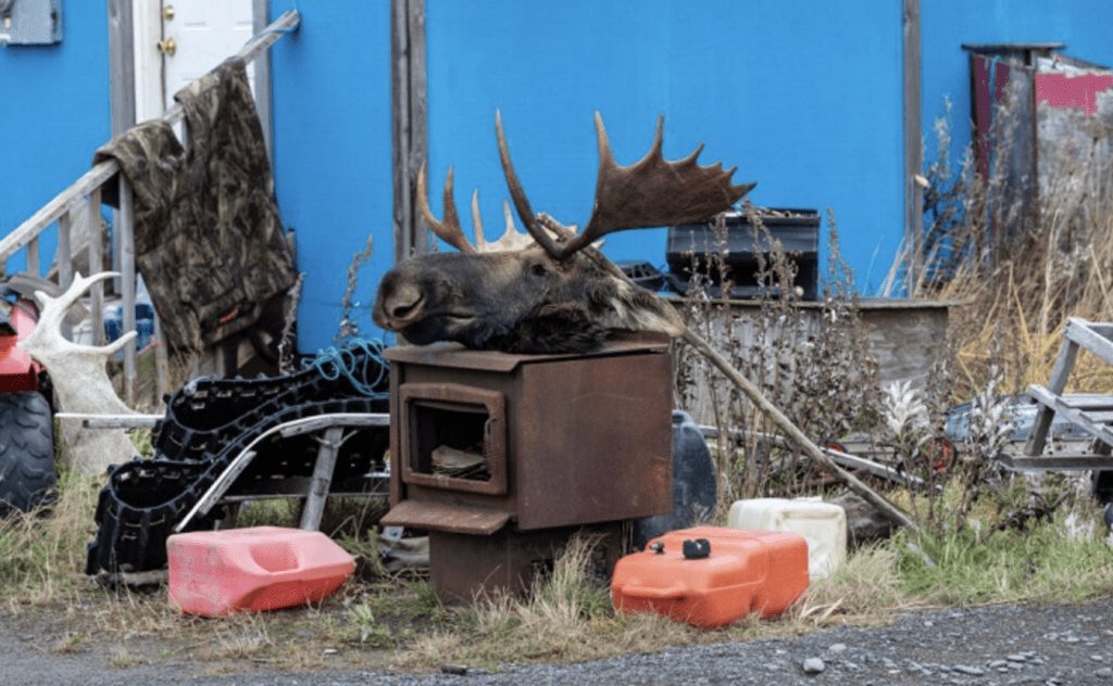 Collection of random junk and Alaska objects outside a house. 