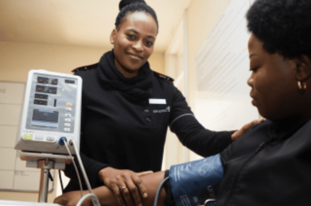 Woman taking another woman's blood pressure