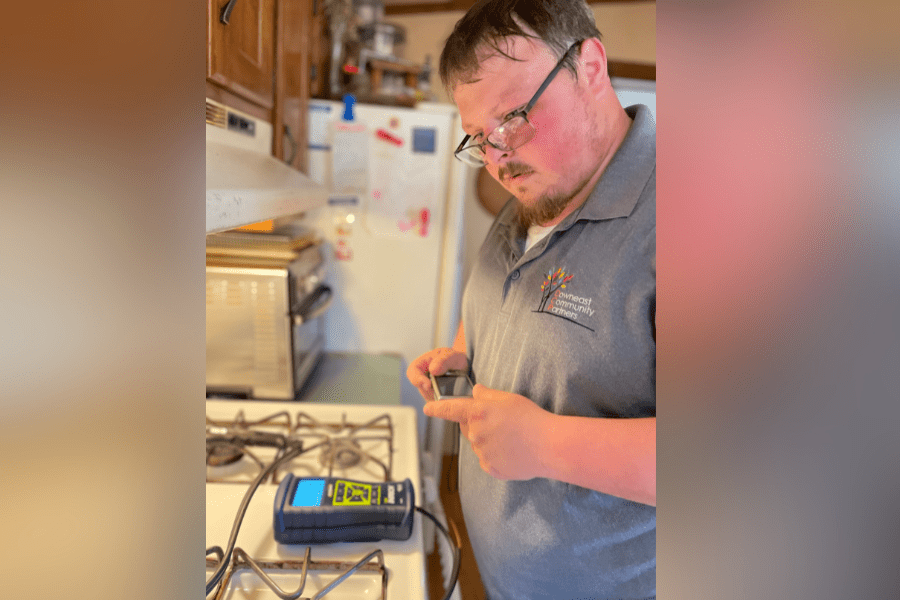 Cory Falabella conducting an energy audit on a stove.