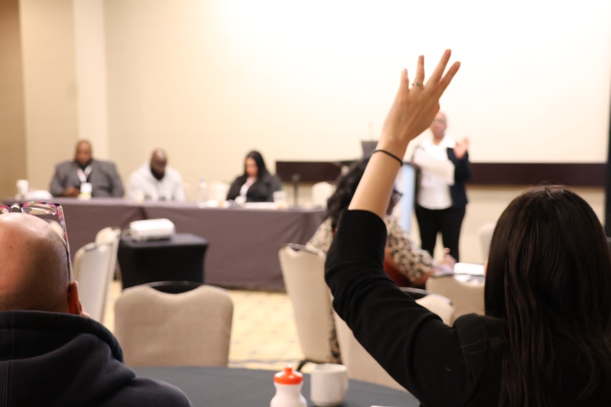 Woman raising her hand to a panel