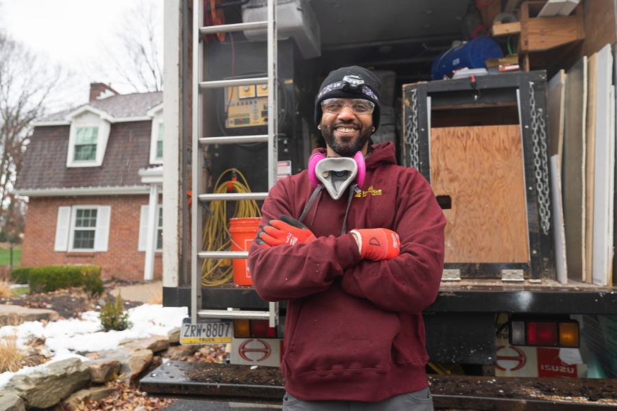 Man standing in front of work truck smiling
